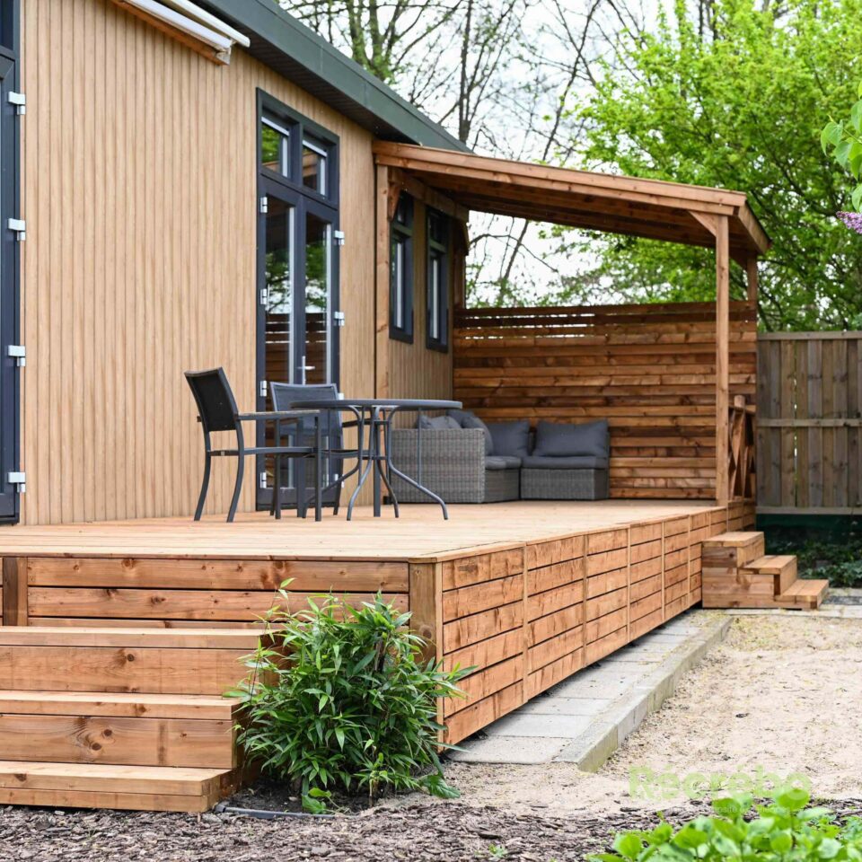 Lichte, houten vakantiewoning met een groot terras en een veranda.