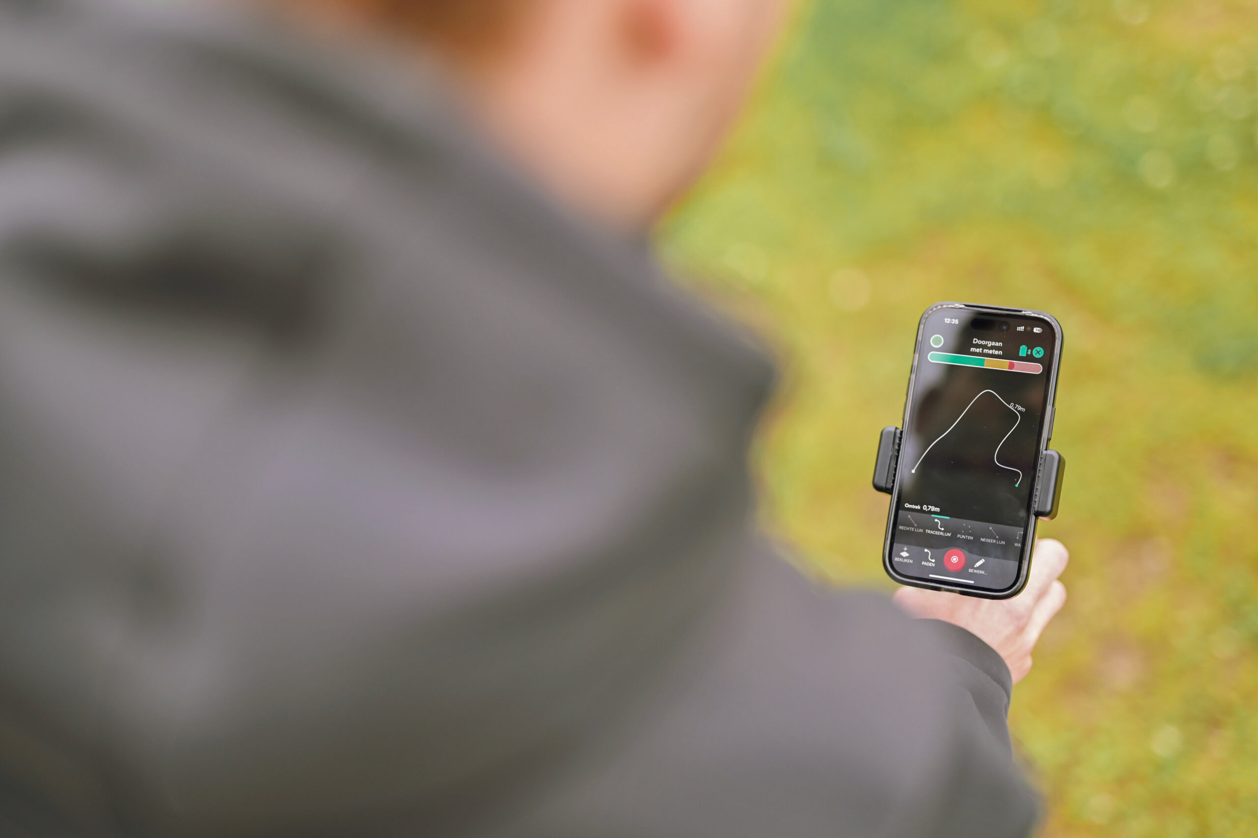 Iemand bekijkt een app met een route op een smartphone.