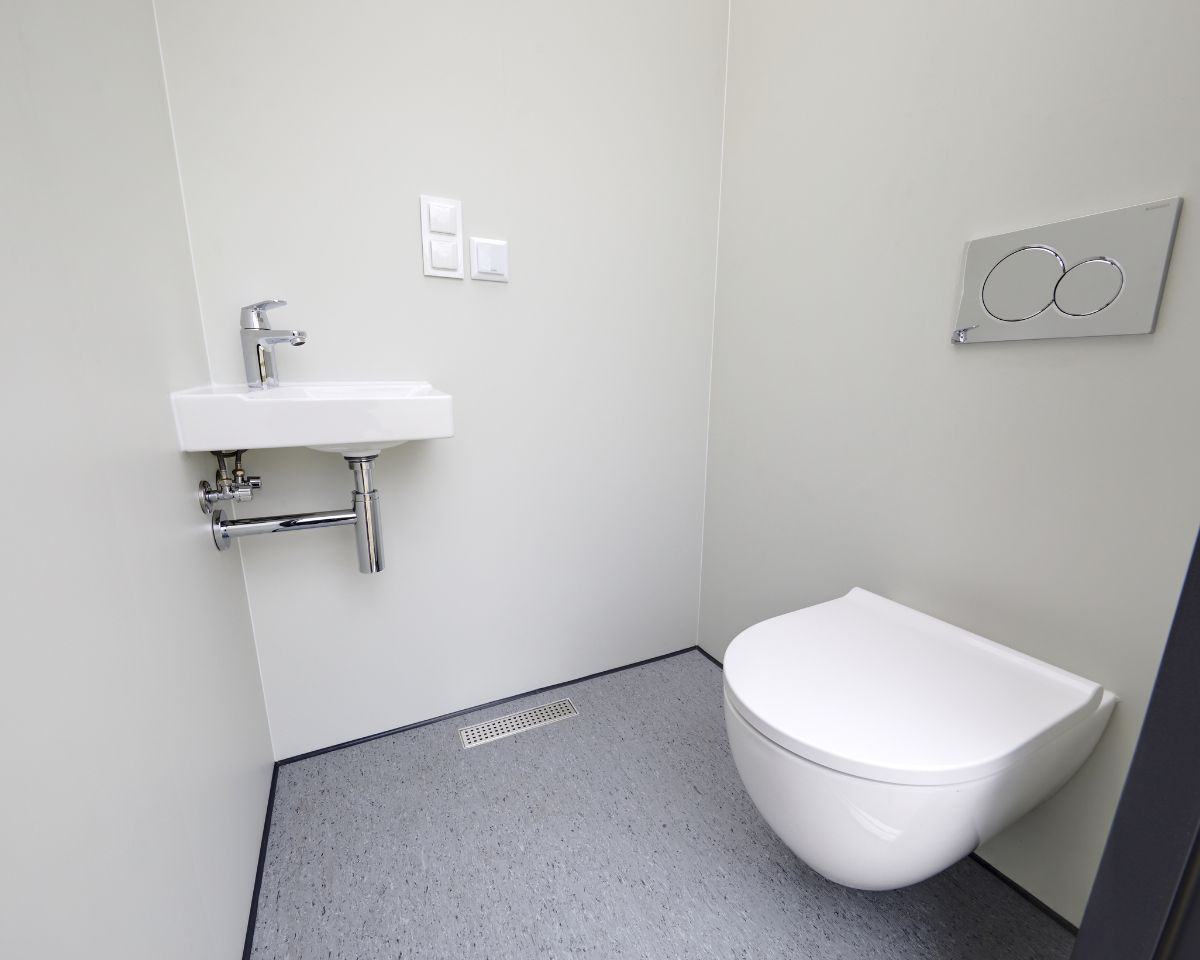 Lichte en schone toiletruimte met wastafel en toilet.