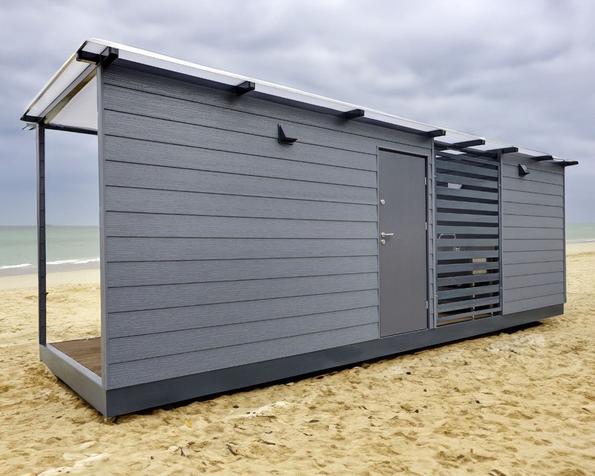 Grijze cabana met terras op het strand.